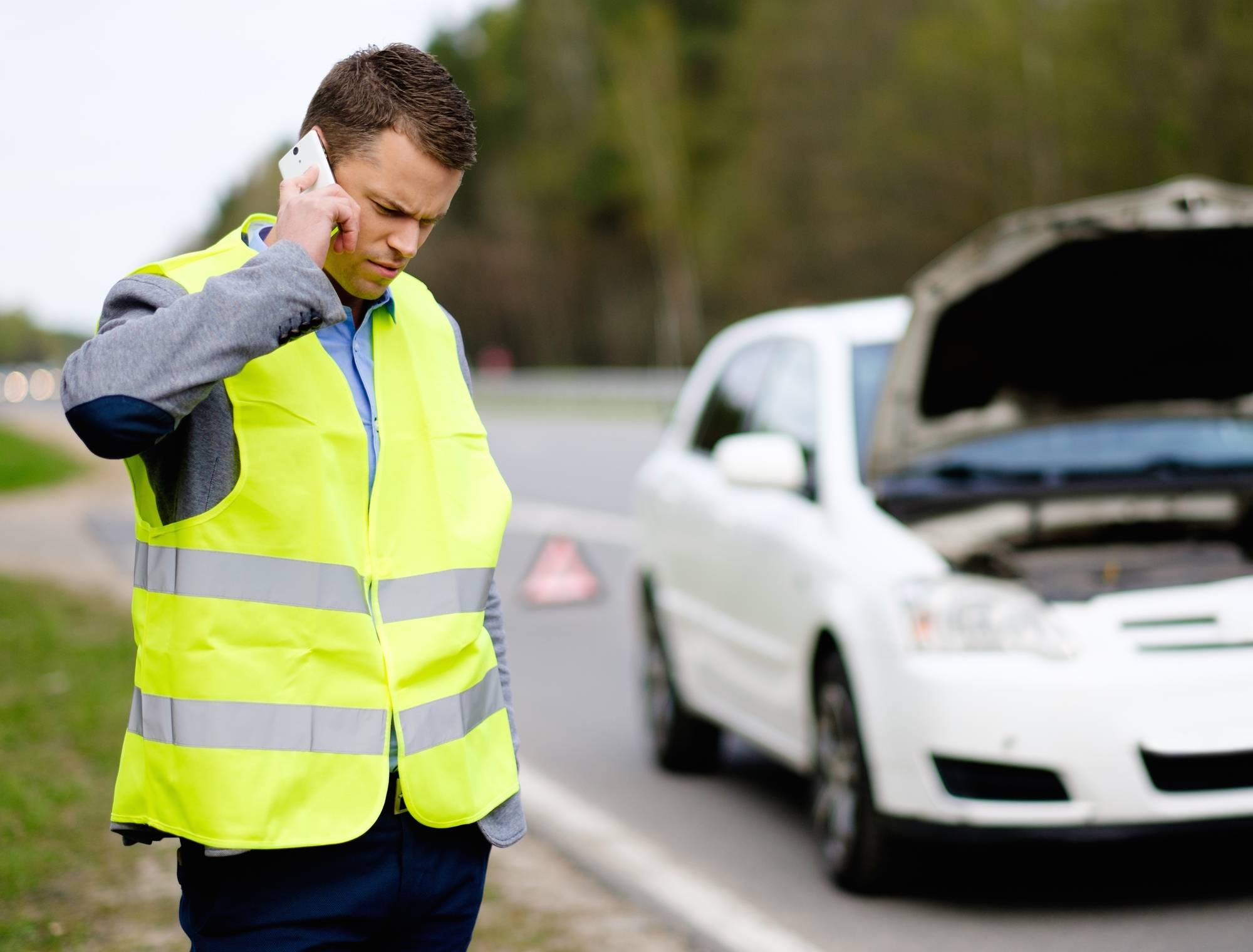 Man Calling Car Towing Service On A Highway Roadside